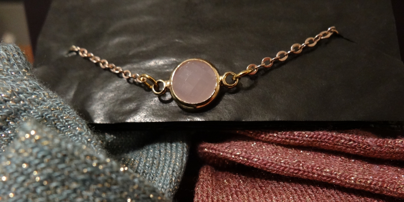 Un bracelet doré avec perle rose
