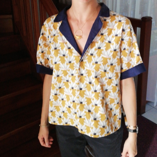 Une chemise jaune à fleurs et revers bleus